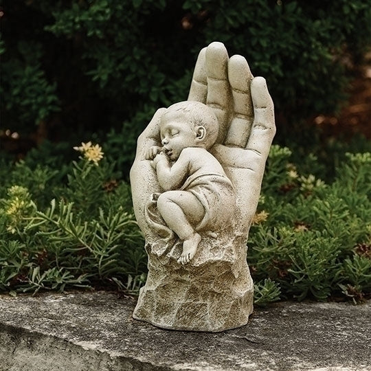 Garden statue of peacefully sleeping baby nestled in large protective hand, symbolizing eternal love and divine care, 11.2 inches tall.