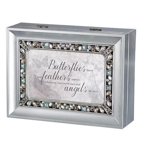 Silver keepsake music box with decorative jeweled frame and sentimental "Butterflies hover, feathers appear" inscription