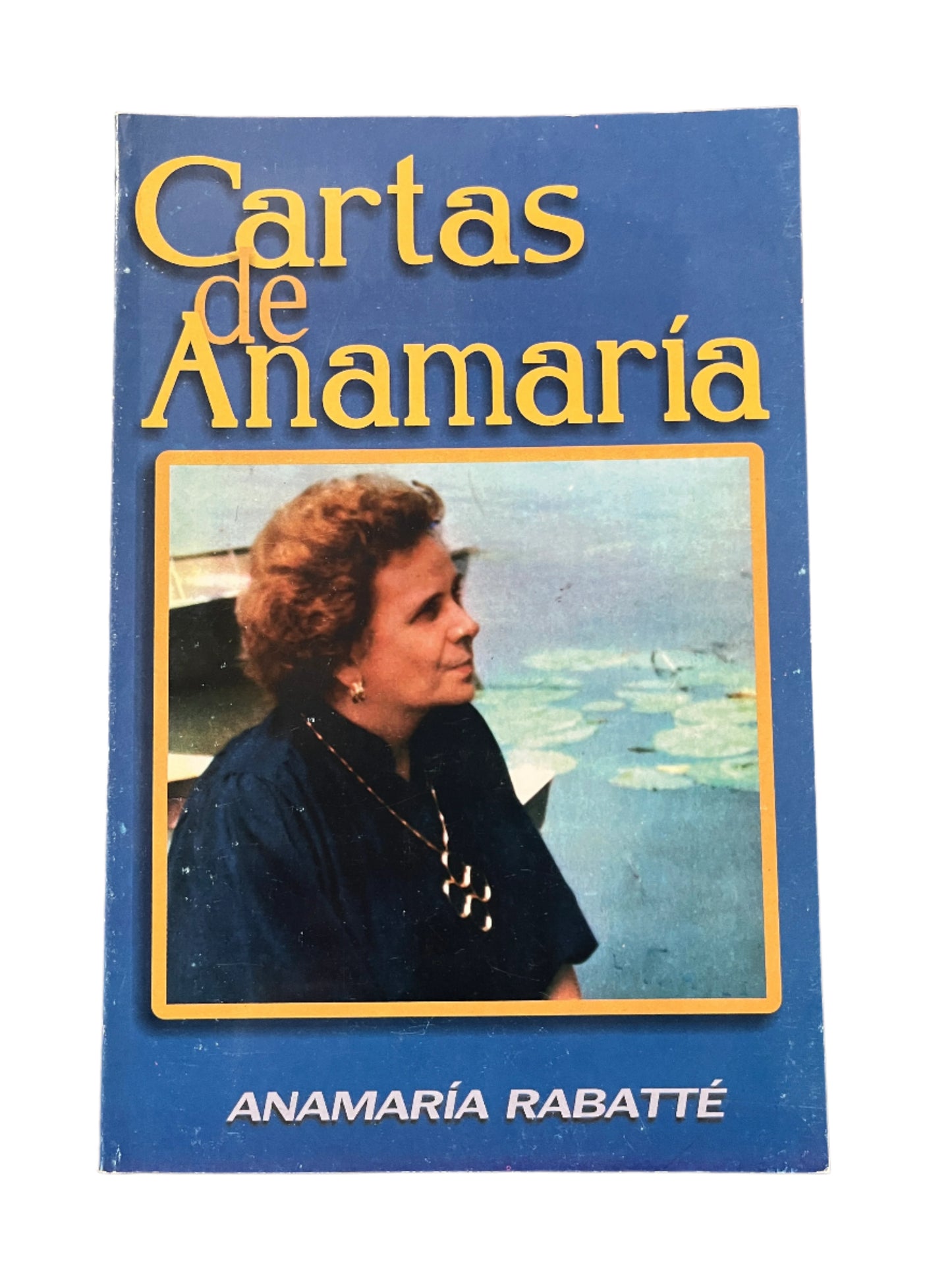 Cartas de Anamaría book cover with a blue background and photo of Anamaría Rabatte by a pond with lily pads