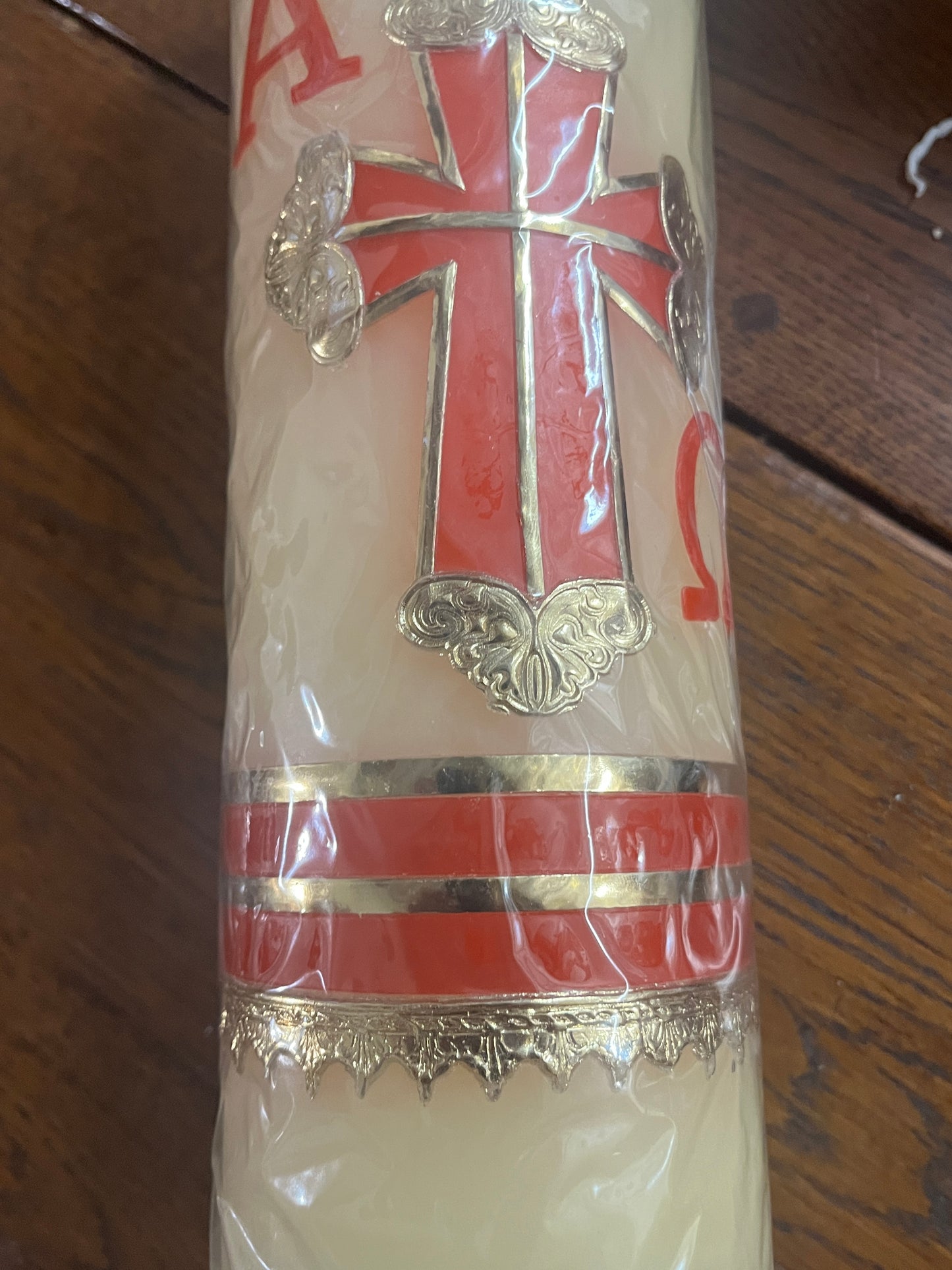 11-inch carved beeswax candle with red Alpha Omega symbols, Lamb of God detail, and gold accents for Catholic worship.