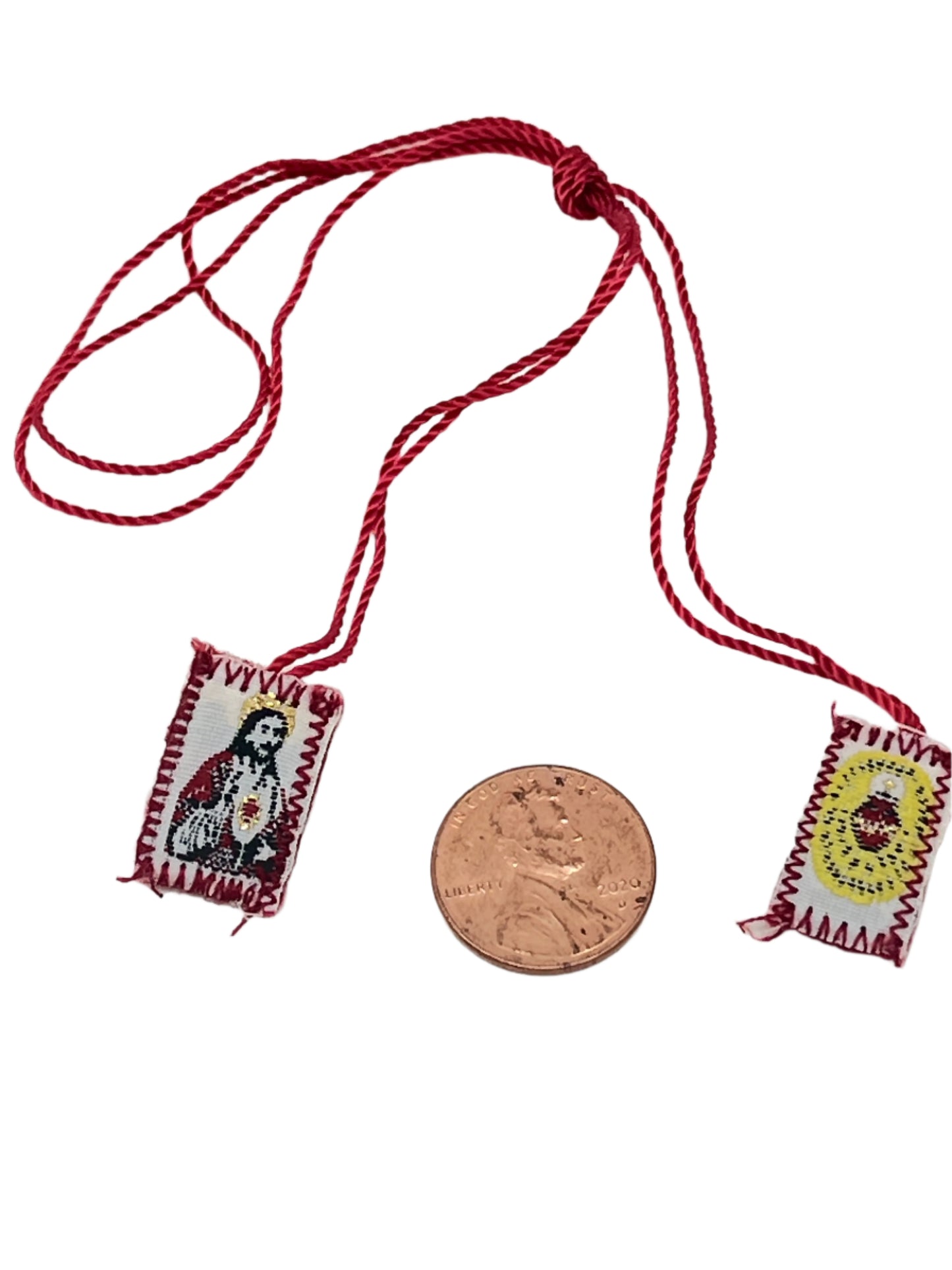 Small Detente red scapular with Sacred Heart of Jesus shield badges, 3/4" size shown next to penny for scale