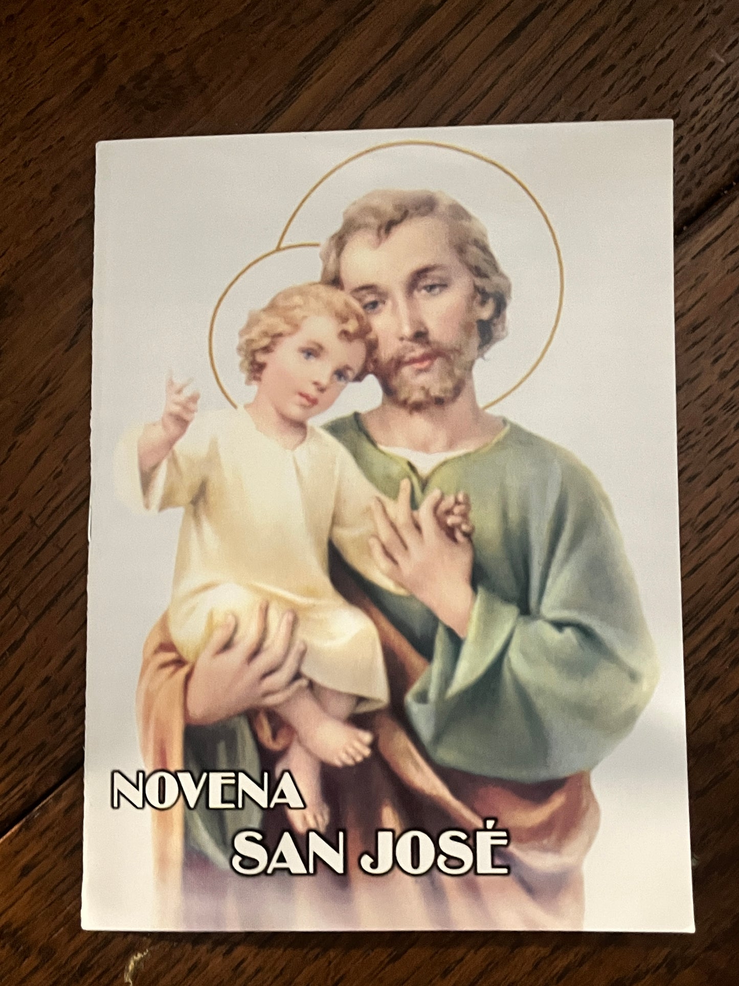 Prayer booklet titled Novena San José featuring Saint Joseph holding baby Jesus with halos on white background