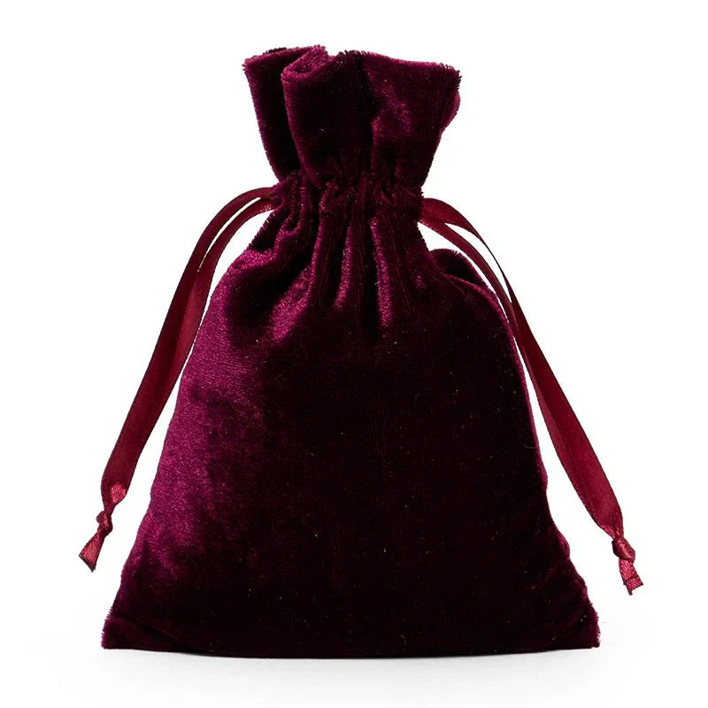 Medium burgundy velvet drawstring bag with soft texture and ribbon pulls for secure closure and elegant style.