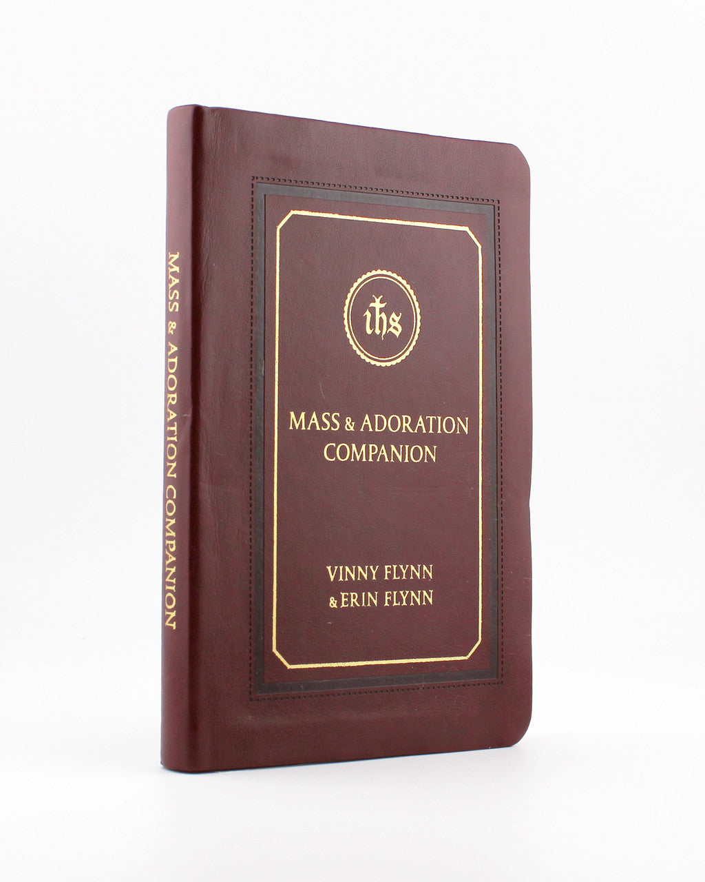 Brown leather-bound book titled Mass & Adoration Companion by Vinny Flynn and Erin Flynn with gold embossed text and design