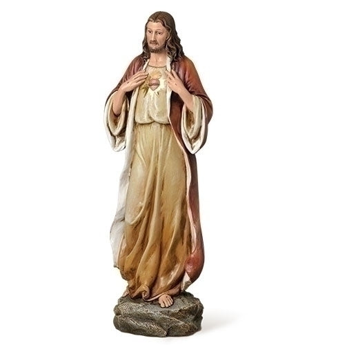 Statue of the Sacred Heart of Jesus standing on a rock base with detailed robes and a glowing heart symbol on chest