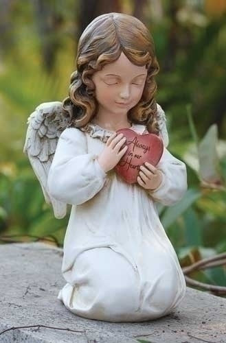 Kneeling angel figurine with white robe and wings holding a red heart inscribed with Always in my Heart.