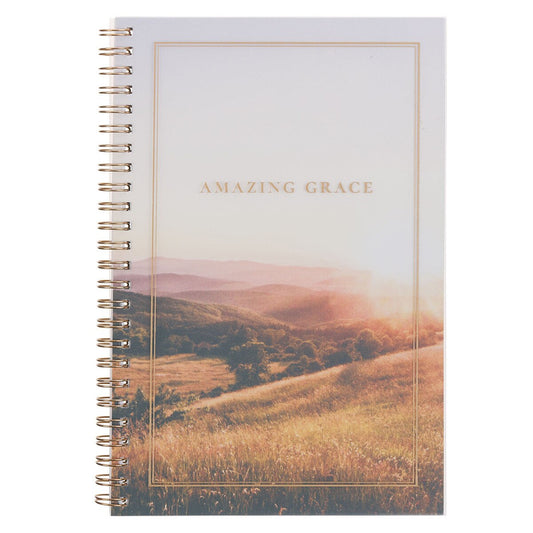 Spiral notebook with Amazing Grace gold text and scenic sunrise over rolling hills on soft pastel cover