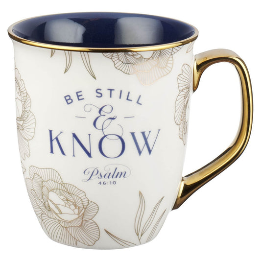Ceramic mug with blue interior, gold handle, floral accents, and Psalm 46:10 "Be Still and Know" text design
