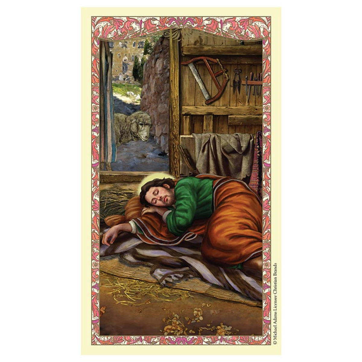 Laminated holy card depicting Saint Joseph sleeping in detailed workshop with tools, sheep outside, and ornate floral border