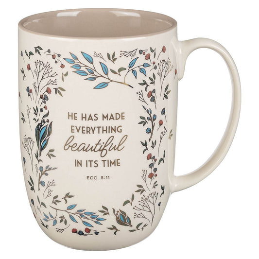 Ceramic coffee mug in cream color with floral design and Ecclesiastes 3:11 Bible verse in brown and blue accents