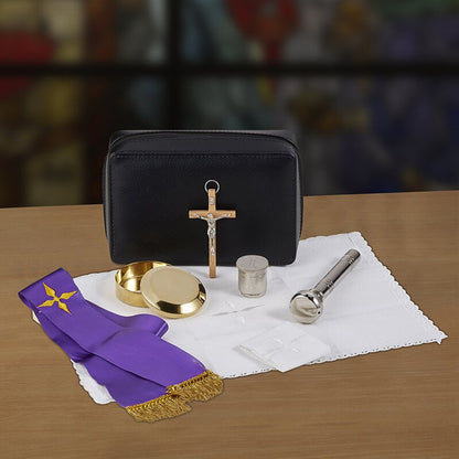 Pastoral Sick Call Set with black carrying case, crucifix, purple stole, pyx, container, and white cloth on wooden surface