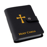 Black faux leather holy card wallet with gold cross and text, secured with snap button closure on white background