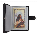 Black faux leather holy card wallet open to show plastic sleeves holding religious cards on white background