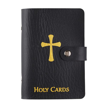 Black faux leather holy card wallet with gold cross and text, secured with snap button closure on white background