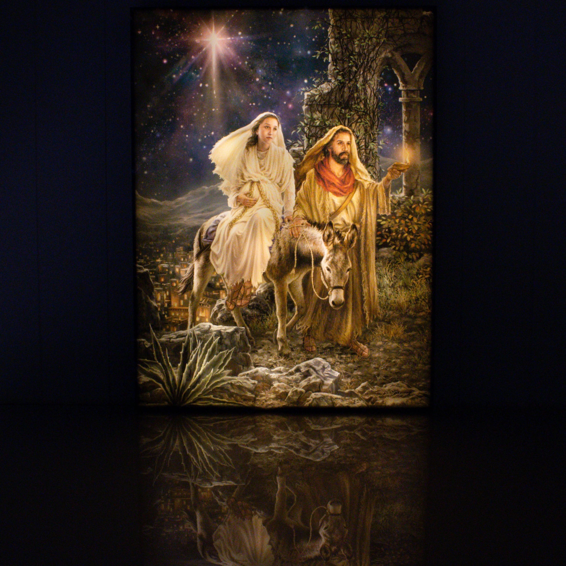 Illuminated 18" x 24" canvas print of Mary and Joseph's journey to Bethlehem with starry night and lantern light