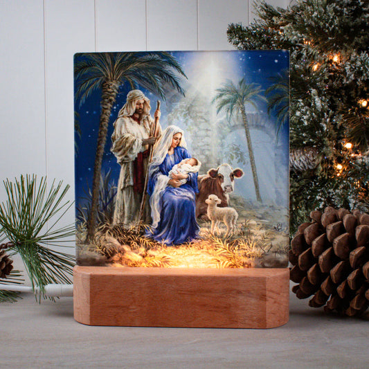 Holy Night tabletop ornament nightlight showing Mary, Joseph, baby Jesus, cow, and lamb with palm trees and starry sky