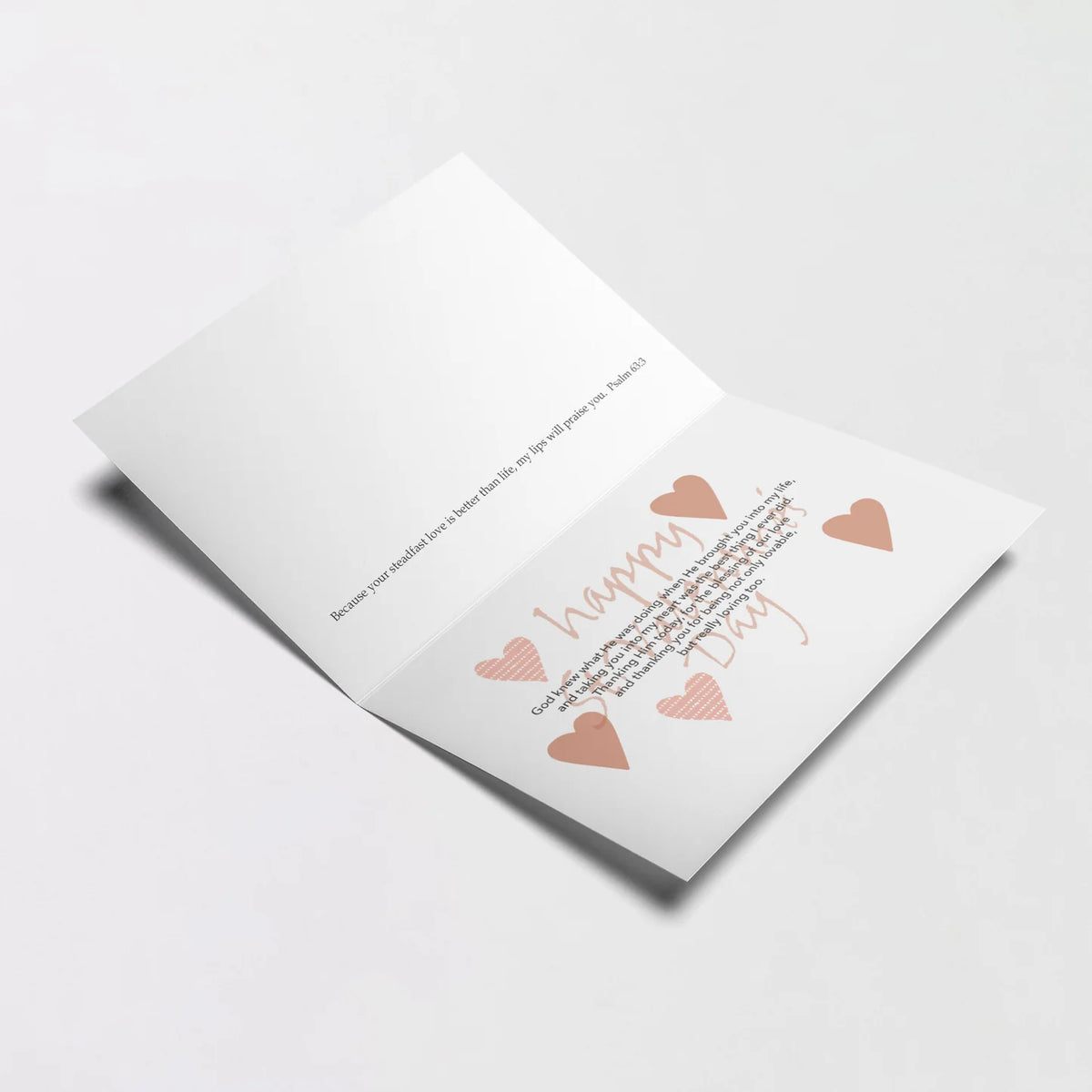 Open St. Valentine's Day greeting card with printed loving message and heart illustrations on white background