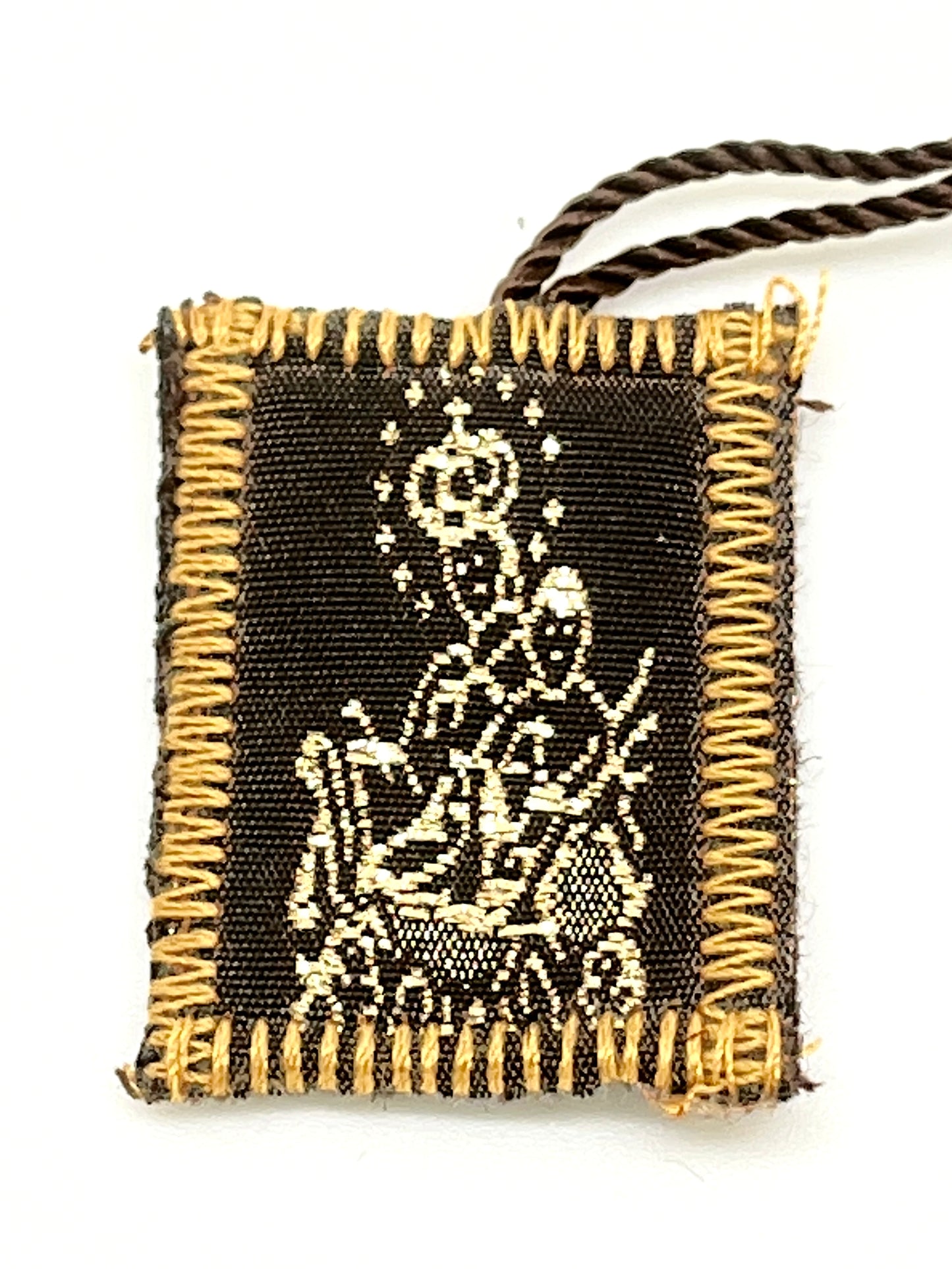 Brown scapular with wool embroidery depicting Our Lady of Mount Carmel, edged with tan stitching and attached cords
