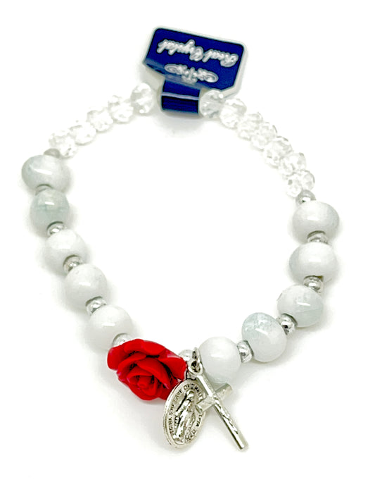 Stretch rosary bracelet with clear and white beads, red rose Our Father bead, and silver Miraculous Medal charm.