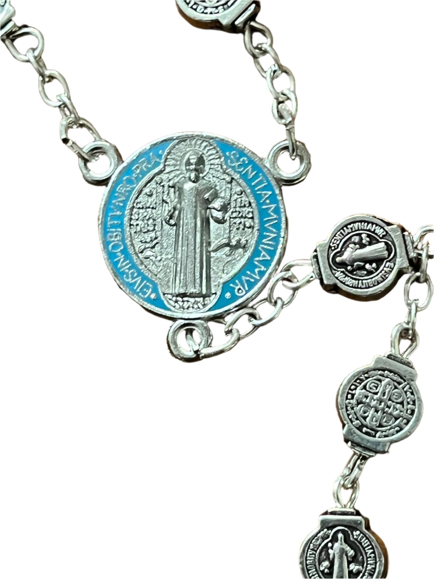 Silver St. Benedict Rosary centerpiece with color-splashed blue enamel, silver medals, and detailed chain links close-up view
