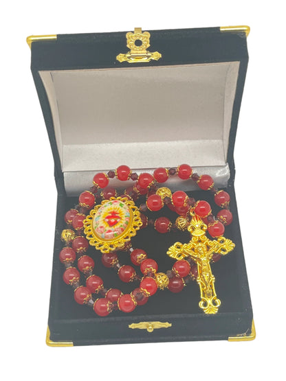 Immaculate Heart of Mary Rosary with deep red gold-capped beads, gold filigree centerpiece, and ornate gold crucifix in black box