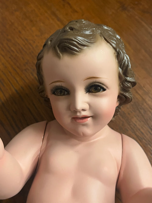 Hand-painted 8-inch Baby Jesus figurine with realistic glass eyes, detailed features, and movable arms, crafted by Mexican artisans.