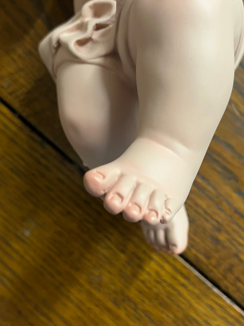 Close-up of Baby Jesus figurine foot crafted from resin with delicate hand-painted details by Mexican artisans