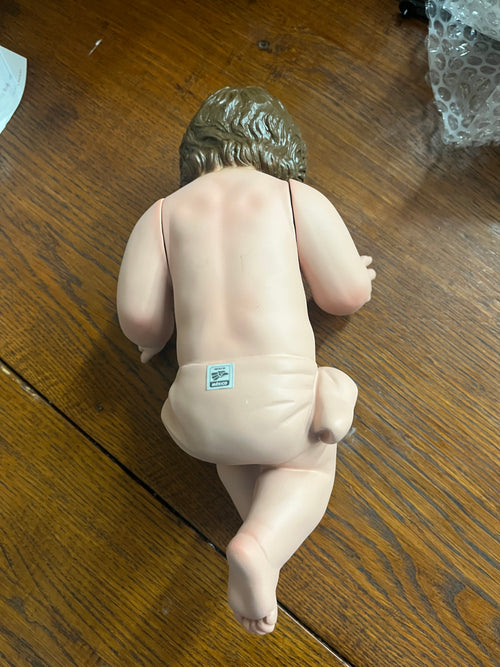 Hand-painted 8-inch Baby Jesus figurine made from resin mix with movable arms and realistic glass eyes, shown from back.
