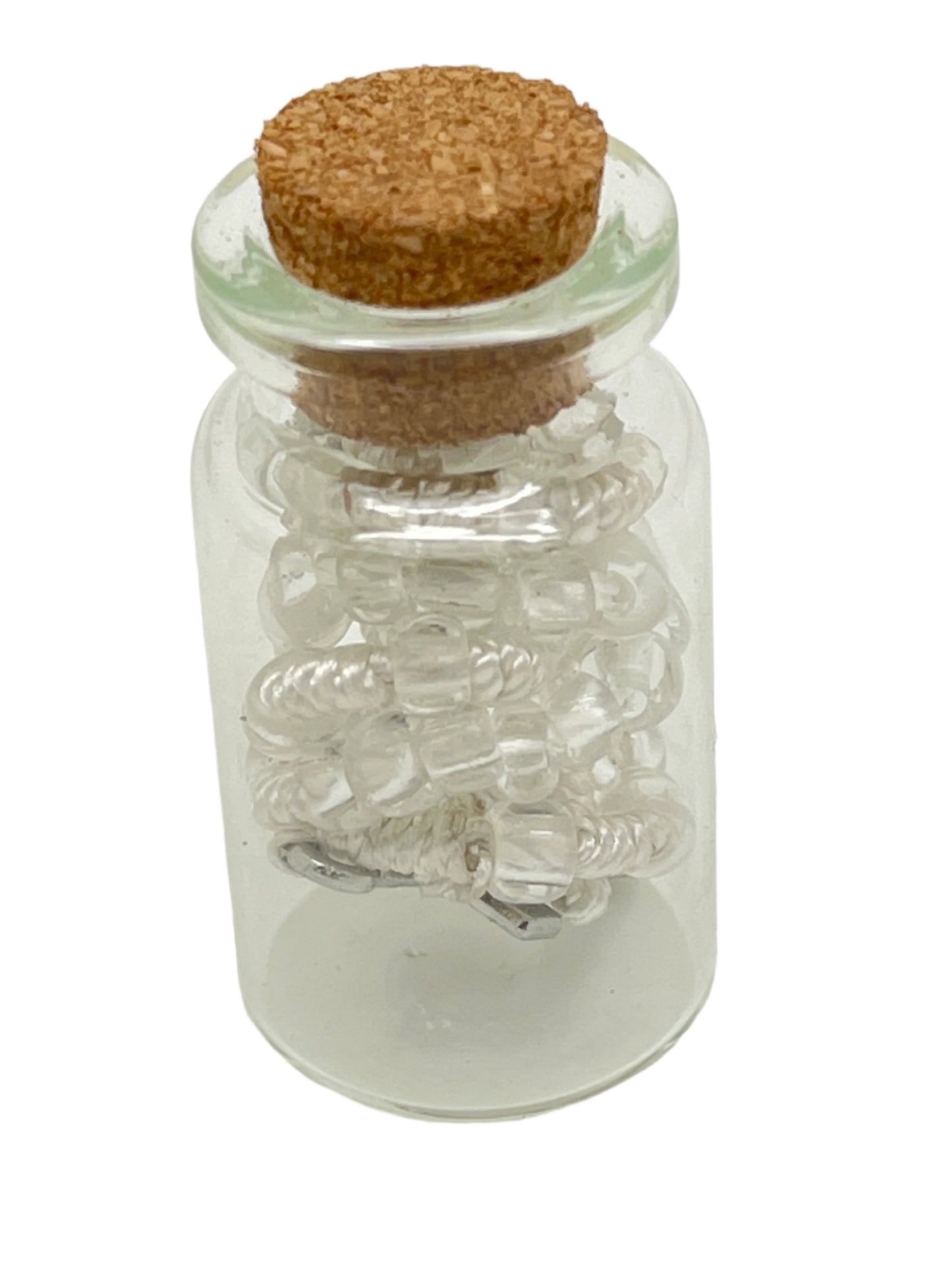 Small white and clear bead rosary neatly coiled inside a clear glass bottle with cork stopper, gift idea for special occasions