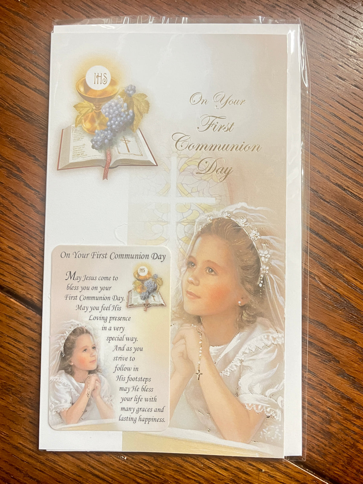 First Communion card for a girl with a holy card featuring blessings and religious imagery on a beige background.