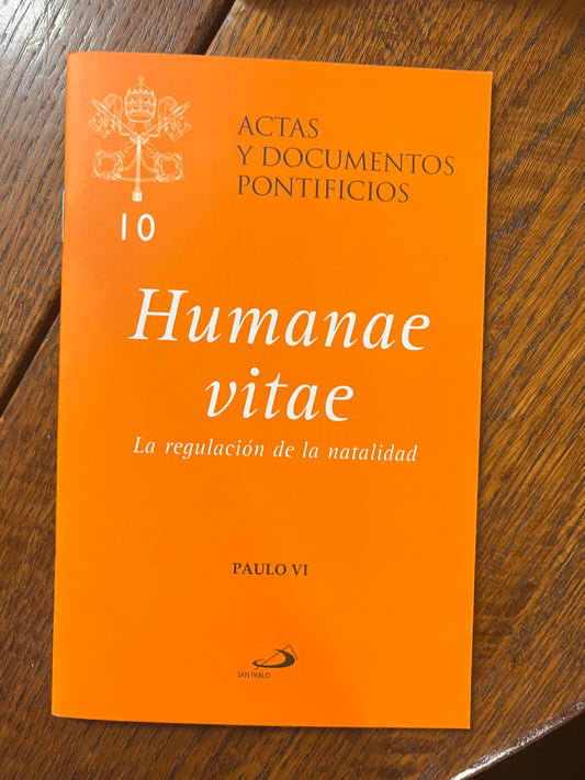 Humanae Vitae book with orange cover, Spanish text on birth regulation by Pope Paul VI, Acta y Documentos Pontificios series
