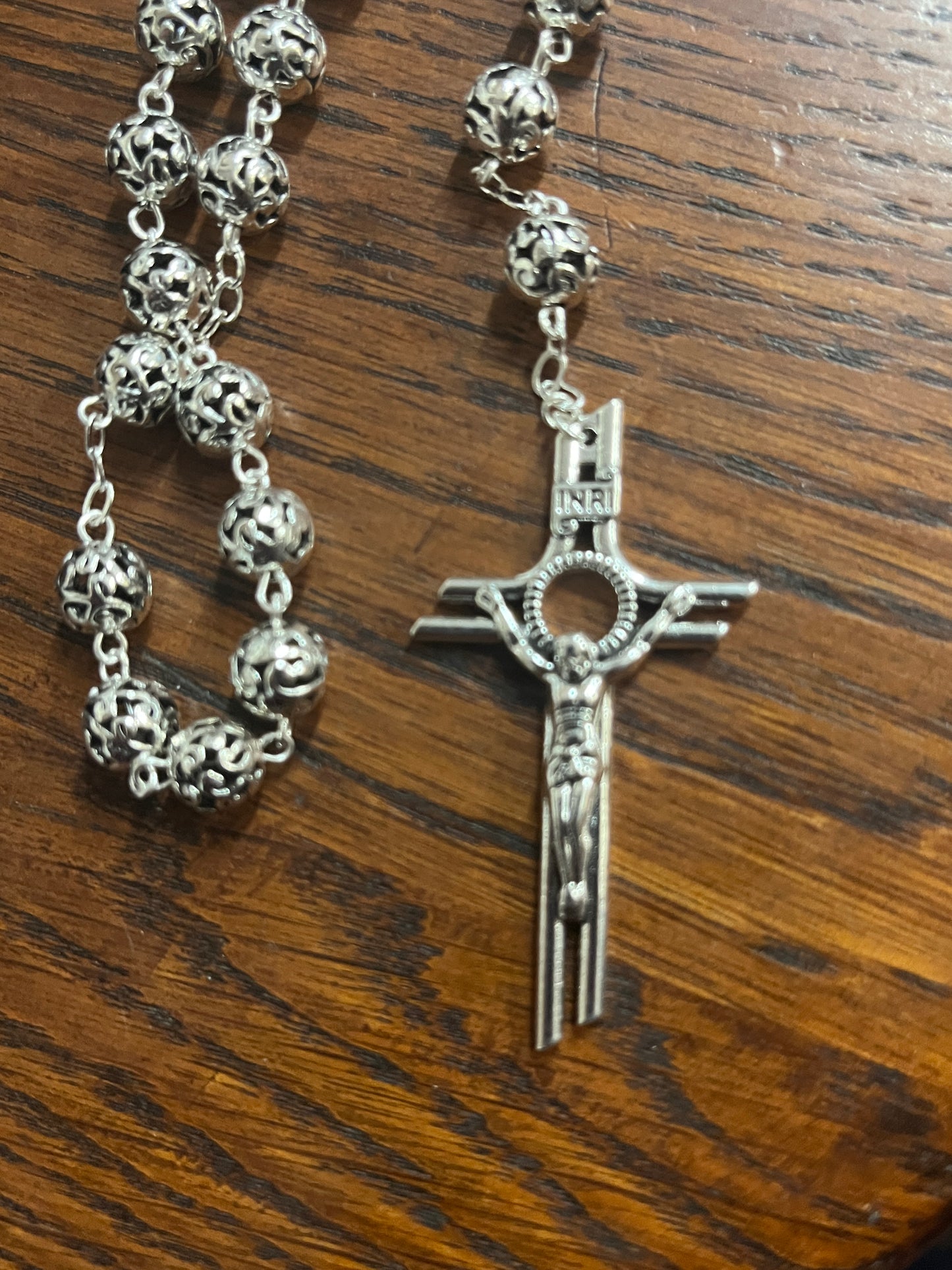 Metal Filigree Rosary with 8 mm intricate filigree beads and detailed crucifix on wooden background