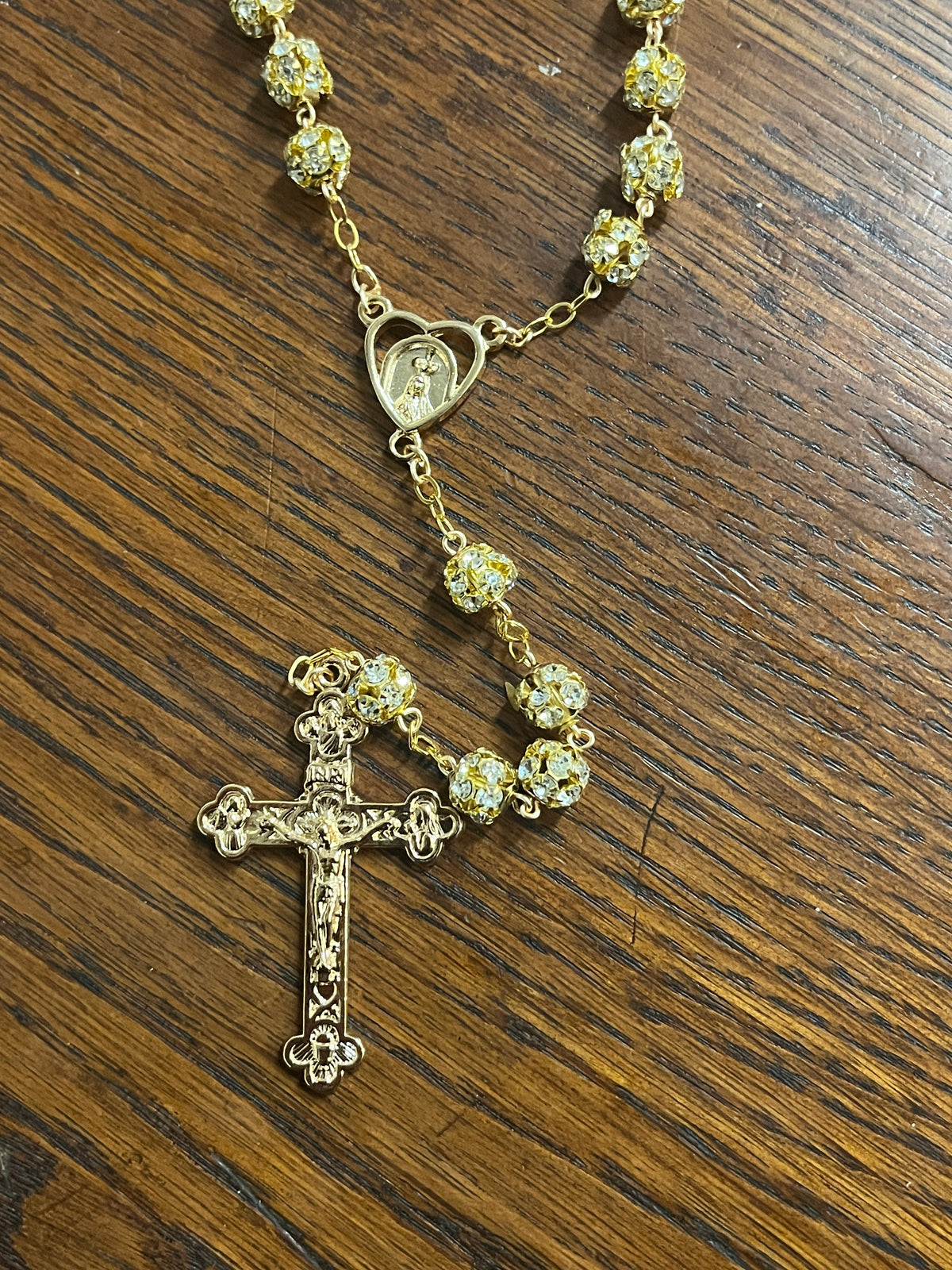 Gold wrapped rosary with sparkling crystal beads and detailed crucifix, crafted in Portugal with delicate religious accents.