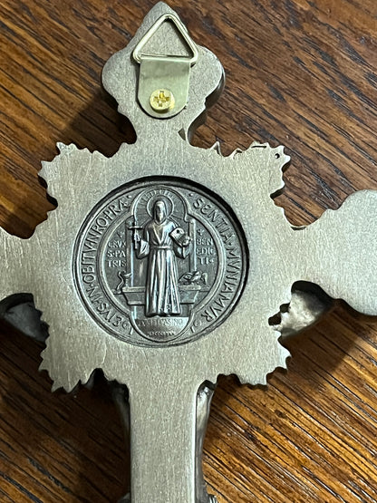 Close-up of St. Benedict medal on bronze-toned standing crucifix with detailed engraving and wall hanging hook