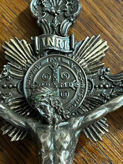 9 3/4" cold cast bronze standing crucifix with detailed corpus, INRI plaque, and Saint Benedict medal background