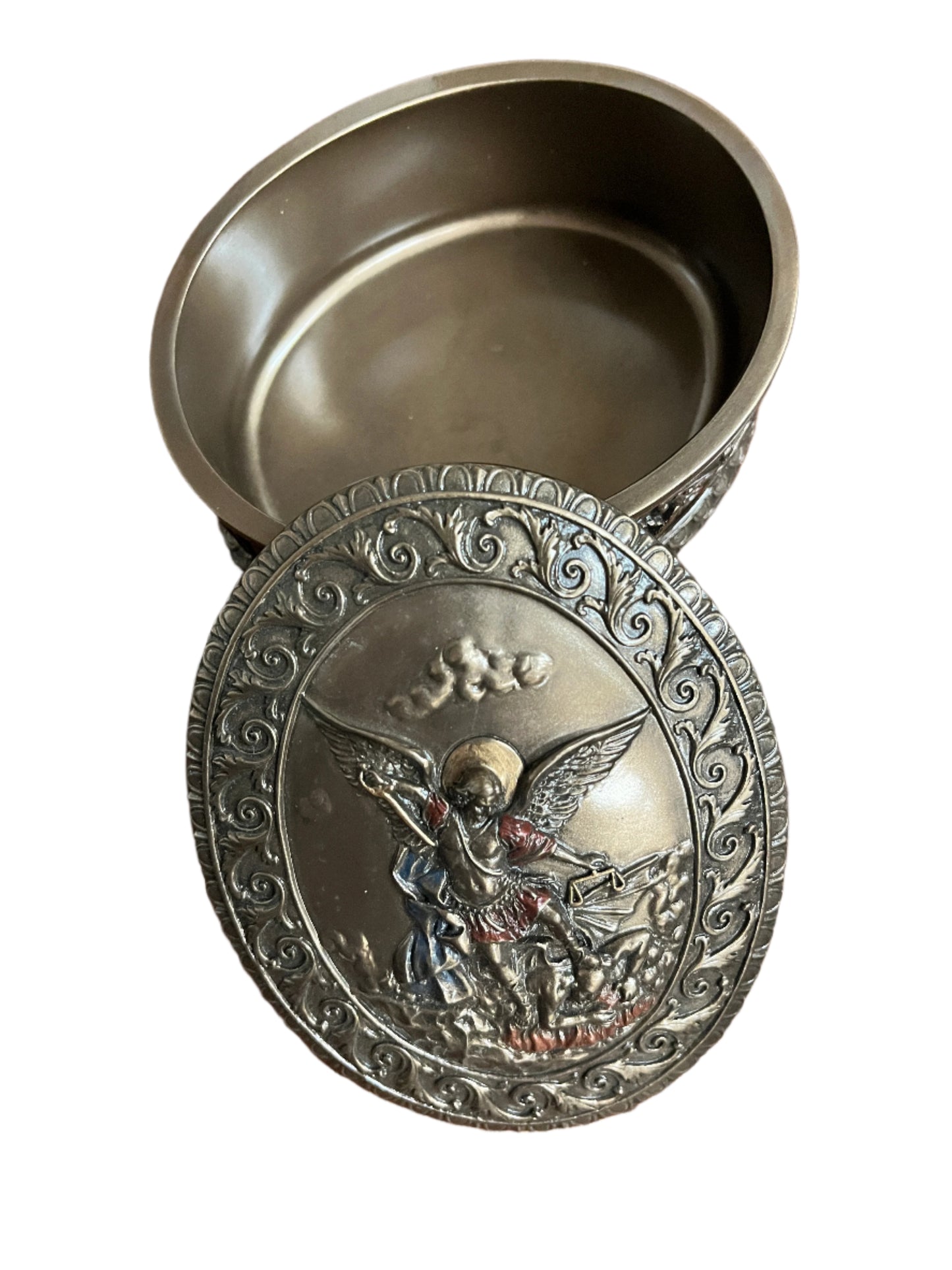 4 3/4" oval bronze keepsake box with detailed Saint Michael relief and ornate scrollwork border on lid