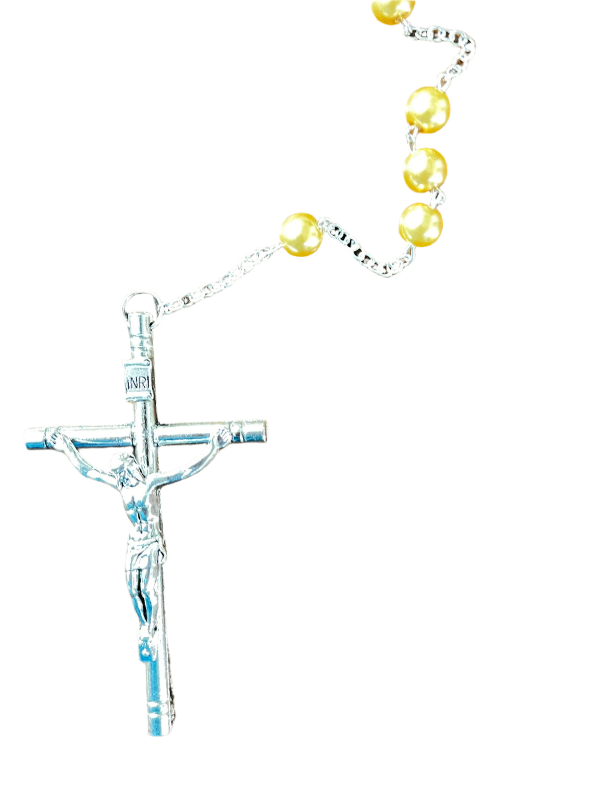 Close-up of silver crucifix with INRI inscription and gold faux pearl beads on fine chain rosary against white background
