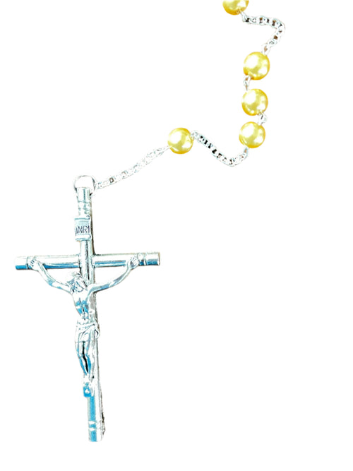 Close-up of silver crucifix with INRI inscription and gold faux pearl beads on fine chain rosary against white background