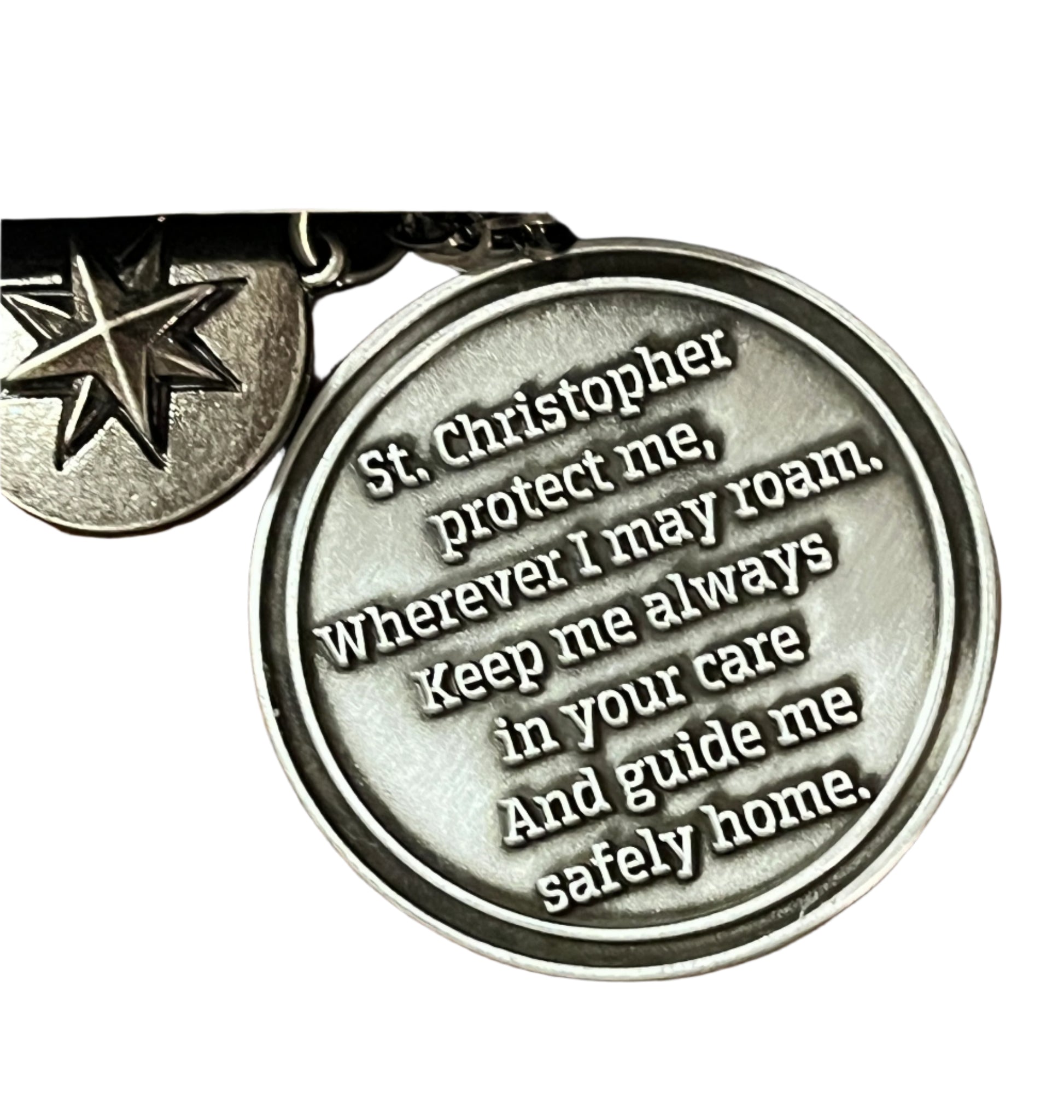 Close-up of round St. Christopher medal car charm with protective prayer inscription and star charm on chain