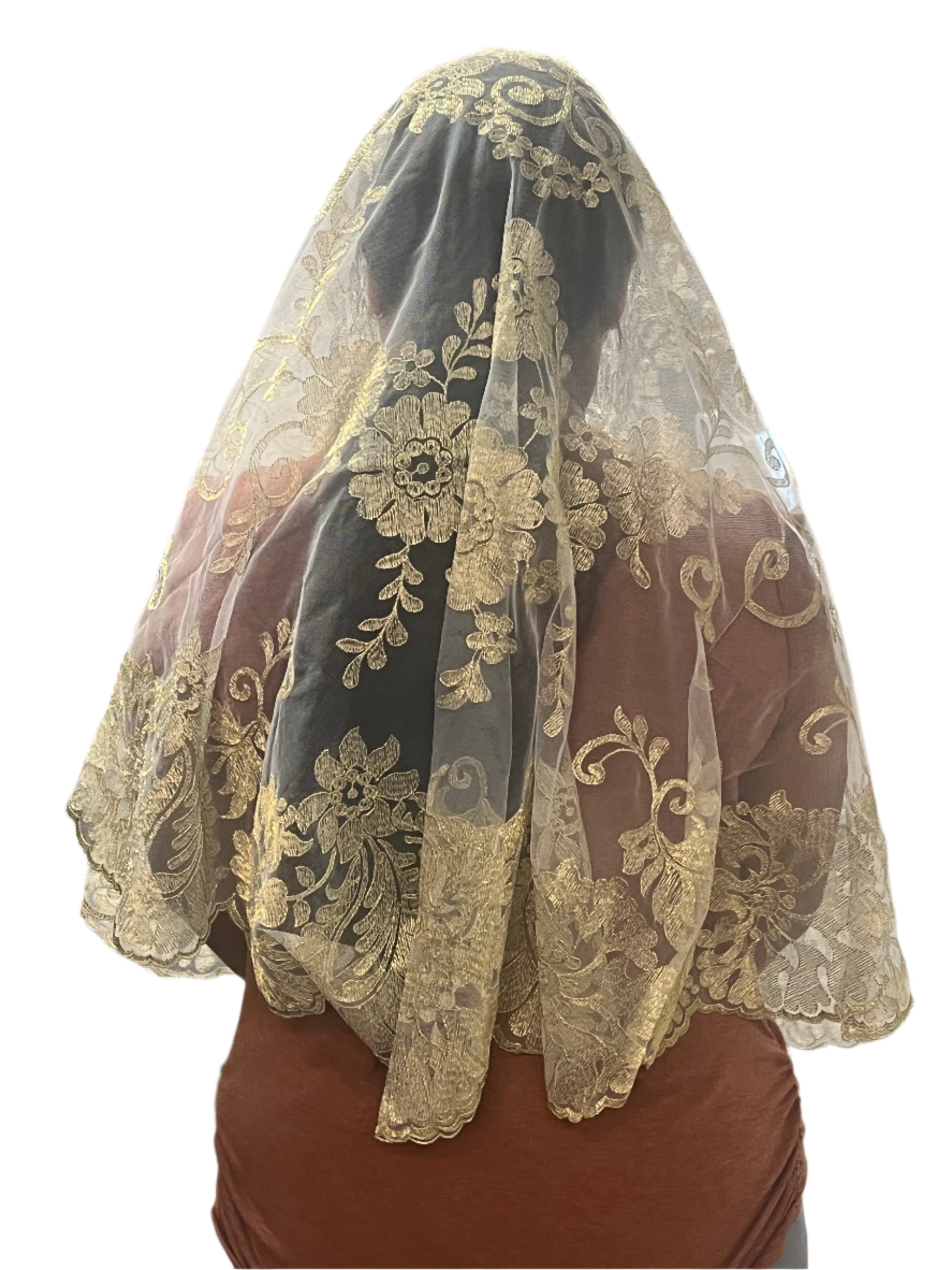 White Spanish lace mantilla veil with intricate floral motifs and scalloped edges worn over head and shoulders