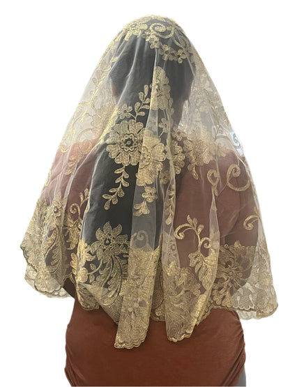 White Spanish lace mantilla veil with intricate floral motifs and scalloped edges worn over head and shoulders