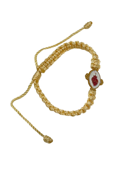 Adjustable Detente woven bracelet with red Sacred Heart emblem and gold-tone braided cord design