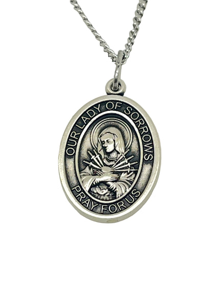 3/4" Our Lady of Sorrows sterling silver oval medal pendant on 18" rhodium curb chain with engraved devotional inscription