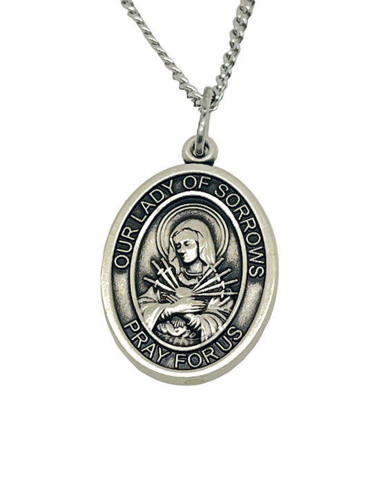 3/4" Our Lady of Sorrows sterling silver oval medal pendant on 18" rhodium curb chain with engraved devotional inscription