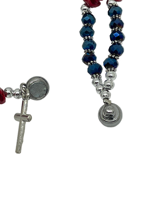 Blue bead full rosary bracelet with red rose accents, silver crucifix, and Miraculous Medal charm on white background