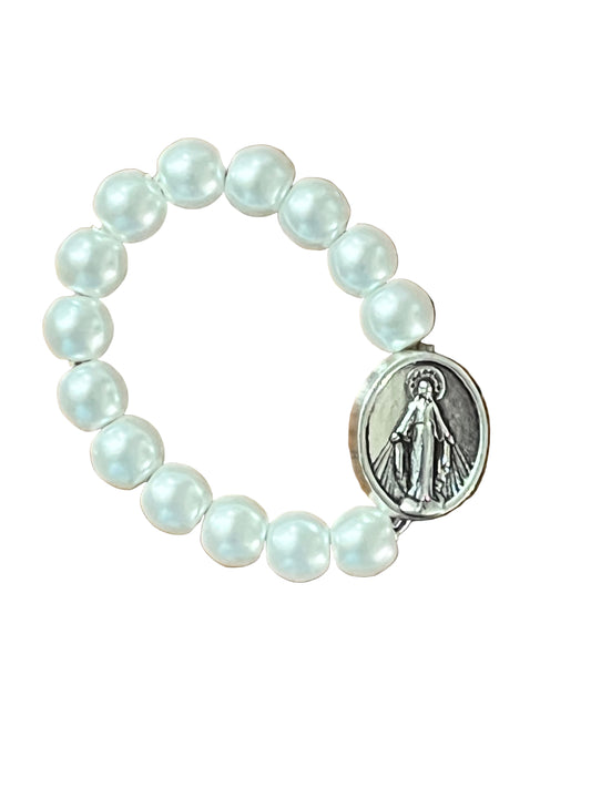 Stretch ring with white beads and silver tone Miraculous Medal centerpiece on white background