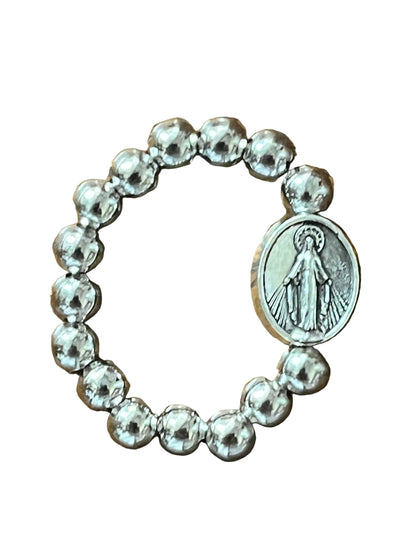 Silver stretch ring with round beads and oval Miraculous Medal charm featuring Virgin Mary image on white background