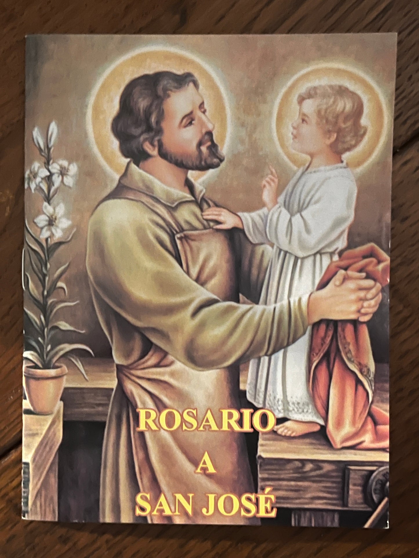 Spanish prayer book titled Rosario a San Jose with illustration of Saint Joseph holding baby Jesus with halos