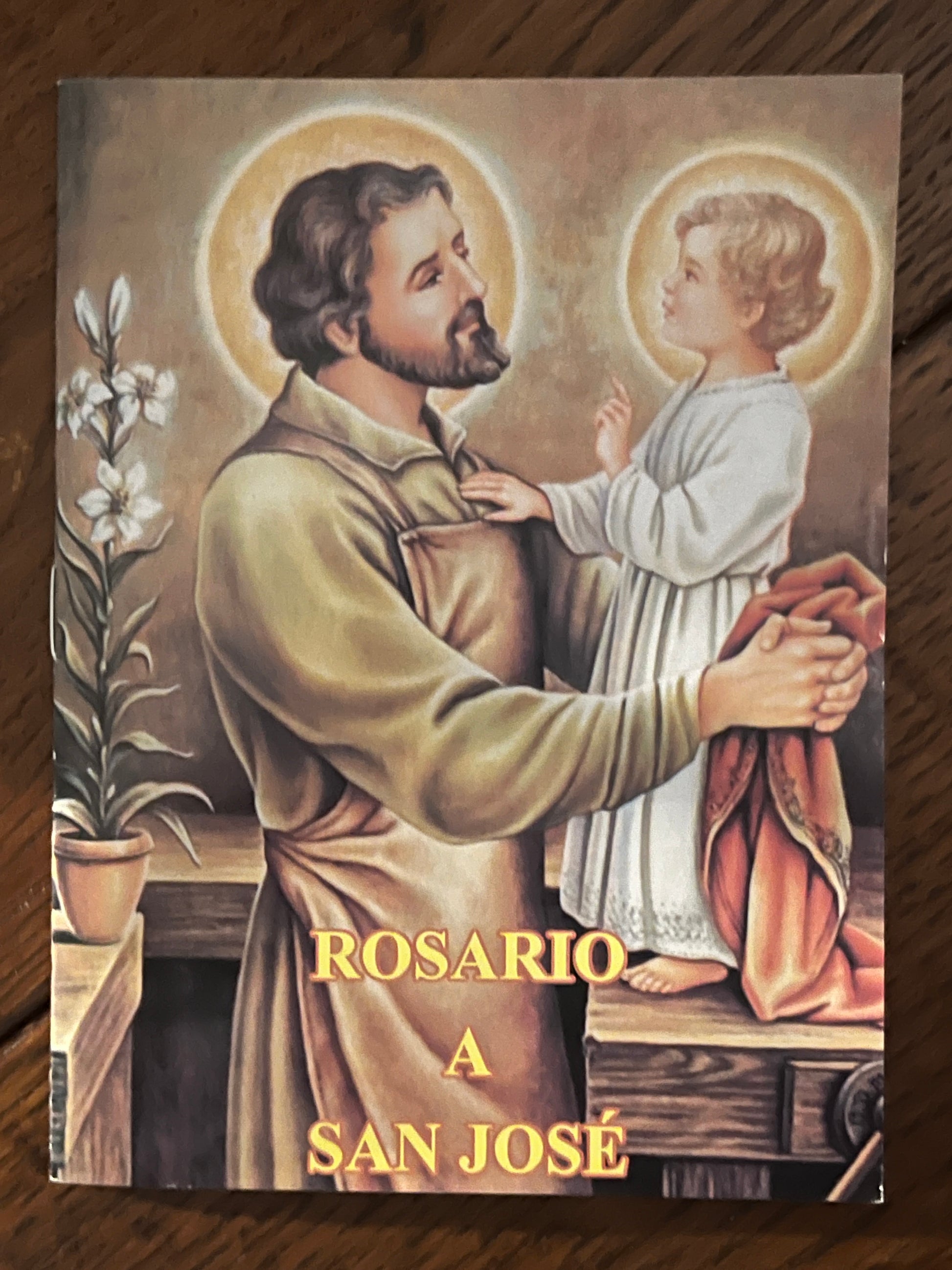 Spanish prayer book titled Rosario a San Jose with illustration of Saint Joseph holding baby Jesus with halos