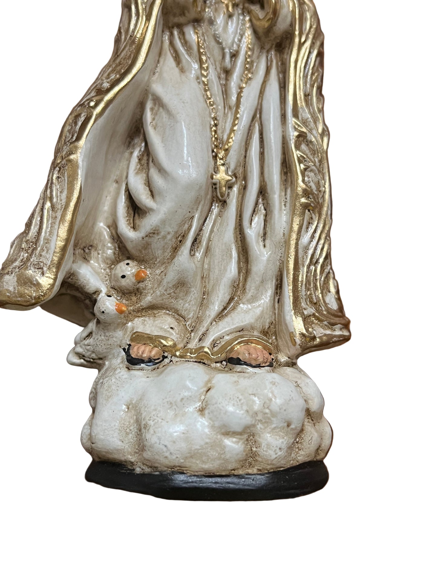 Close-up of Our Lady of Fatima statue base with golden robe, rosary, and two white doves on cloud-shaped pedestal